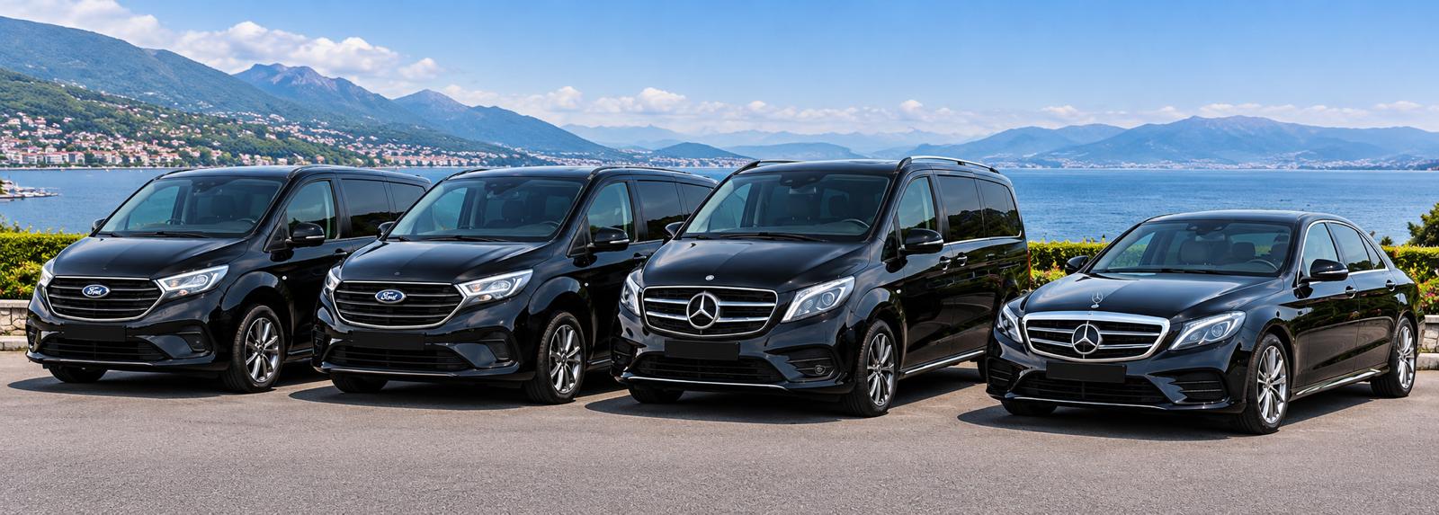 The BuxTravel fleet of black Mercedes-Benz and Ford Tourneo vehicles lined up by the water